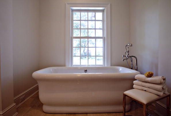 A bathtub sits in the "hers" bathroom in the master suite of